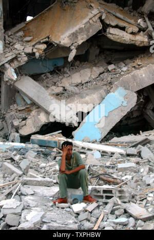 A Palestinian boy sits on the rubble of his home that was destroyed ...