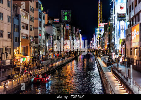 Osaka, Japan - April 13, 2019: Minami Namba famous street with people walking shopping in dark night and illuminated buildings by Dotombori river Stock Photo