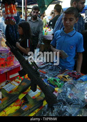 A Palestinian boy looks at a toy gun at the popular Firas market in Gaza on October 11, 2007. Muslims all over the world are preparing for the Eid al-Fitr holiday which begins early tomorrow, marking the end of the holy fasting month of Ramadan.(UPI Photo/Ismael Mohamad) Stock Photo