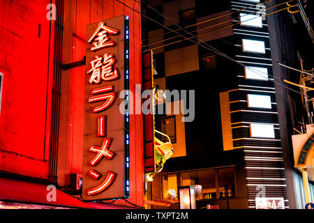 Osaka, Japan - April 13, 2019: Minami Namba famous street with red neon ramen sign in dark night and illuminated buildings Stock Photo