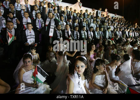 Palestinian girls, dressed as bridesmaids, during a mass wedding in Jabalya in the northern Gaza Strip July 30, 2009. Some 450 couples were married in Jabalya in a group wedding organized by the Islamic Society, a group affiliated to Hamas. The newly wedded brides held a separate closed-door celebration for their weddings.(UPI photo /Ismael Mohamad)