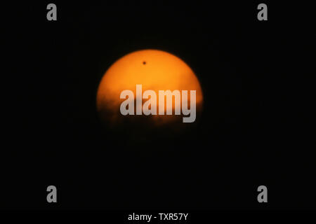 The planet Venus is seen through a special solar filter as a black dot while it transits across the sun in Gaza, on June 6, 2012. The planet Venus made a slow transit across the face of the sun on Tuesday, the last such passing that will be visible from Earth for 105 years. UPI/Ismael Mohamad Stock Photo