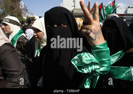 A Palestinian woman raises her hand written with the Arabic words 'our prisoners are our dignity' as she takes part in a protest against the death of a Palestinian detainee in an Israeli jail, in Gaza City on February 24, 2013. A spokeswoman for Israel's Prison Authority said that the detainee, 30-year-old Arafat Jaradat, had apparently died of cardiac arrest. An emergency service team had tried to resuscitate him but failed, she said.    UPI/Ismael Mohamad Stock Photo