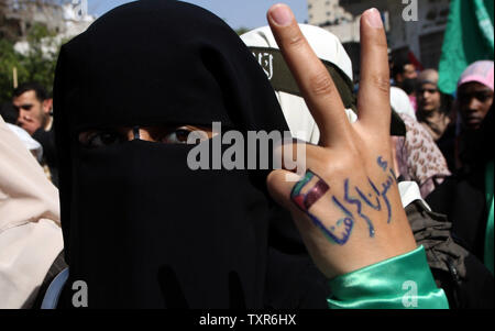 A Palestinian woman raises her hand written with the Arabic words 'our prisoners are our dignity' as she takes part in a protest against the death of a Palestinian detainee in an Israeli jail, in Gaza City on February 24, 2013. A spokeswoman for Israel's Prison Authority said that the detainee, 30-year-old Arafat Jaradat, had apparently died of cardiac arrest. An emergency service team had tried to resuscitate him but failed, she said.    UPI/Ismael Mohamad Stock Photo