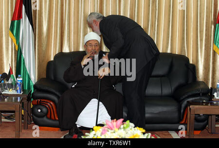 Hamas Prime Minister Ismail Haniyeh (L) kisses the head of Egyptian Cleric and chairman of the International Union of Muslim Scholars, Sheikh Yusuf al-Qaradawi upon al-Qaradawi's arrival at Rafah Crossing in the southern Gaza Strip May 8, 2013. Al-Qaradawi arrived on May 8, 2013 for a three-day visit to Gaza Strip with a delegation of Muslim scholars. UPI/Ismael Mohamad Stock Photo