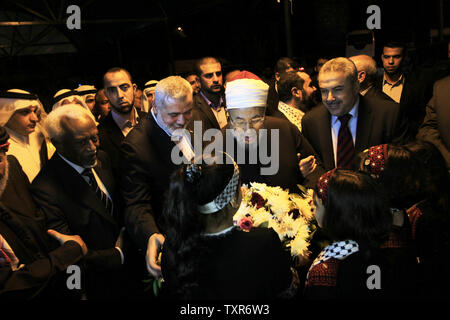 Egyptian Cleric and chairman of the International Union of Muslim Scholars Sheikh Yusuf al-Qaradawi (C) receives flowers from Palestinian girls upon al-Qaradawi's arrival at Rafah Crossing in the southern Gaza Strip May 8, 2013. Al-Qaradawi arrived on May 8, 2013 for a three-day visit to Gaza Strip with a delegation of Muslim scholars. UPI/Ismael Mohamad Stock Photo