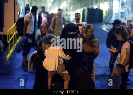 Migrants disembark from the passenger ship 'Tera Jet', following their trip from the island of Lesbos to the port of Piraeus, near Athens, Greece on September 1, 2015. Another 1,700 migrants arrived aboard the ferry to Piraeus from the island of Mytilene, migrants arriving on its eastern Aegean islands, with more than 160,000 landing so far this year. Europe is struggling to respond to its biggest migration crisis since World War II, with more than 300,000 people arriving this year. photo by Yuksel Pecenek/ UPI Stock Photo