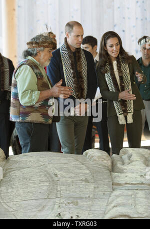 Prince William and his wife Kate, the Duke and Duchess of Cambridge talk to a master totem pole carver in the Carving House of the Haida Heritage Centre and Museum at Kaay Llnagaayin, Haida Gwaii, BC during the 2016 Royal tour of British Columbia (BC) and the Yukon, September 30, 2016. UPI/Heinz Ruckemann Stock Photo