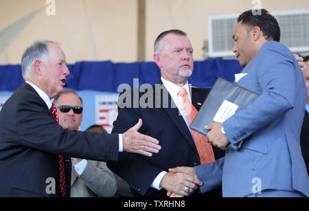 Newly elected members to the National Baseball Hall of Fame (L to R) Pat Gillick, and Bert Blyleven congratulate Roberto Alomar for his remarks during induction ceremonies in Cooperstown, New York on July 24, 2011.   UPI/Bill Greenblatt Stock Photo