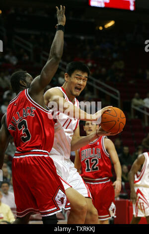 Houston Rockets' Yao Ming drives the ball to the basket while being defended by the Chicago Bulls' Ben Wallace during the second period at the Toyota Center in Houston, November 16, 2006.  (UPI Photo/Johnny Hanson) Stock Photo