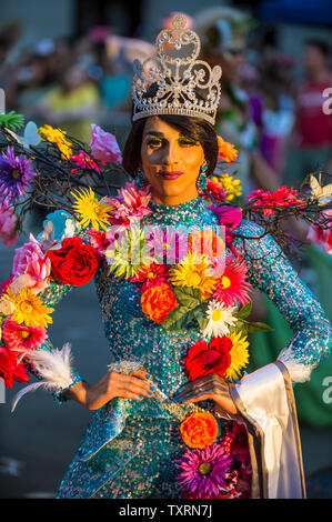 NEW YORK CITY - JUNE 25, 2017: A transgender drag performer wearing flowers with her beauty queen tiara passes on a float in the gay Pride parade. Stock Photo