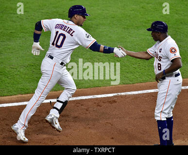 Houston Astros Yuli Gurriel (L) scores against New York Yankees catcher  Gary Sanchez in the fifth inning on a double by teammate Brian McCan in  game 7 of the American League Championship