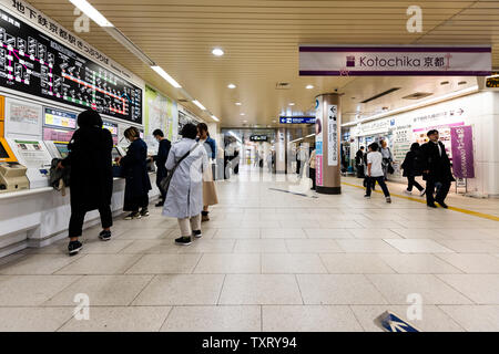 Kyoto, Japan - April 17, 2019: Inside interior of Kyoto Station indoors undergound with people busy walking buying tickets and english sign for kotoch Stock Photo