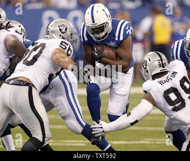 Indianapolis Colts running back Vick Ballard (33) jumps through the Oakland Raiders line as linebacker Kaluka Maiava (5) and defensive end Lamarr Hudson (99) try to make the tackle in the first quarter at Lucas Oil Field in Indianapolis, Indiana on September 9, 2013.  UPI/Mark Cowan Stock Photo