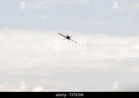 Propeller plane in flight seen from the front with many clouds at an airshow Stock Photo
