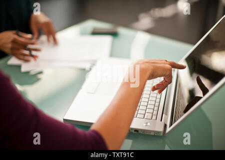 Two colleagues working together on a laptop computer. Stock Photo
