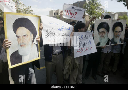 Iranian students hold pictures of Iran's late supreme leader Ayatollah Rohollah Khomeini (L) and Iran's supreme leader Ayatollah Ali Khamenei as they demonstrate in front of the office of Iran's nuclear negotiator to protest Iran's planned talks with the United Nations regarding its nuclear progra, in Tehran on April 8,2006.   (UPI Photo/Mohammad Kheirkhah) Stock Photo