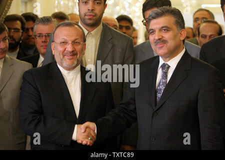 Iran's Foreign Minister Manouchehr Mottaki (L) shakes hand with his Turkish counterpart Abdullah Gul during their meeting in Tehran, Iran, June 25, 2006. On Sunday, Iran rejected reports of suspension of enrichment work for a period of three months. (UPI Photo/STR) Stock Photo