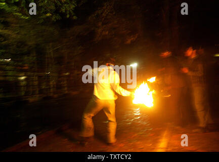 A member of Iran's hardline Islamist Basij militia throws a molotov cocktail at the front of the Danish Embassy in Tehran on October 10, 2006.  Danish television broadcast video footage of  a Danish political youth group that was deemed insulting to the Muslim Prophet Mohammad.  Protesters hurled stones and petrol bombs into the embassy compound.  (UPI Photo/Mohammad Kheirkhah) Stock Photo