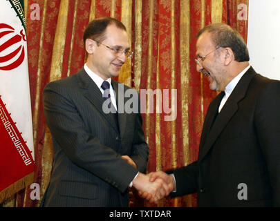 Iranian Foreign Minister Manouchehr Mottaki (R) shakes hands with Russian Federal Atomic Energy Agency (Rosatom) Head Sergei Kiriyenko at a joint press conference in Tehran, Iran on December 11, 2006. Iranian and Russian officials discussed the upcoming launch of a nuclear power plant.   (UPI Photo) Stock Photo