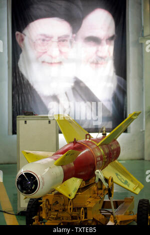 Irans newly developed 'Qased' or harbinger 2000-pound 'smart' bomb is seen in front of a pictures of Iran's supreme leader Ayatollah Ali Khamenei (L) and Iran's late supreme leader Rohollah Khomeini (R), at the production plant in Tehran, Iran on August 25, 2007. The Qased bomb can be deployed aboard Iran's F-5 and F-4 fighters and presumably the upcoming second-generation Saeqeh fighter, acording to Iranian news agencies. Western military experts say it remains unclear if the bomb's precision capability is based on a laser or television guidance system. (UPI Photo/Alireza Sotakbar/ISNA) Stock Photo