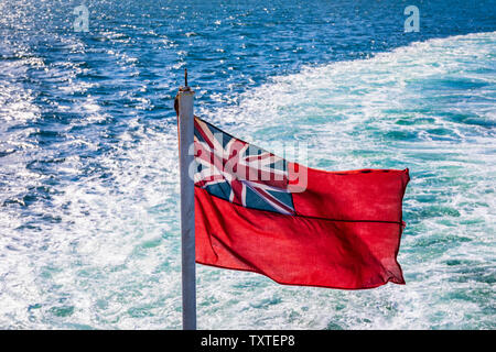 Red ensign flying at the stern of a British passenger ship, Firth of Clyde, UK. The red ensign or Red Duster is the civil ensign of the United Kingdom Stock Photo