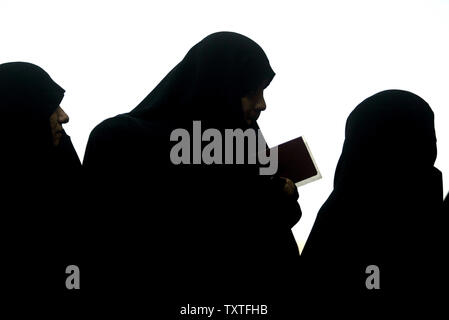 Iranian women are silhouetted while they hold their certificates and stand in line to vote in Iran's parliamentary election at a polling station at the Saint Masoumeh shrine in the holy city of Qom, 80 miles (130 kilometers) south of Tehran, Iran on March 14, 2008. (UPI Photo/Mohammad Kheirkhah) Stock Photo