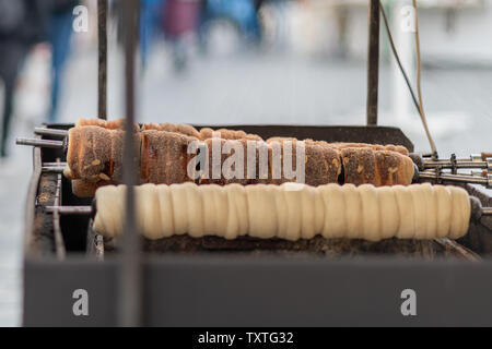 Tasty traditional Czech street festival food called schaumrollen being cooked over an open fire in Prague for the Easter Markets Stock Photo