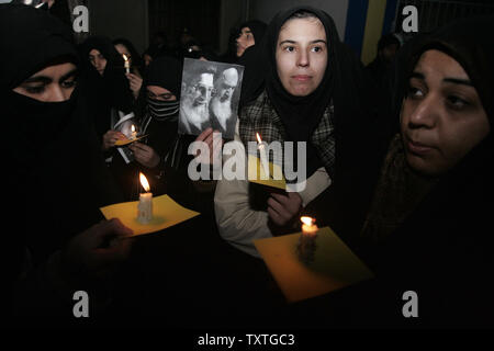 Members of the Basij, a hardline volunteer force established by revolutionary leader Ayatollah Khomeini, hold pictures of Iran's supreme leader Ayatollah Ali Khamenei (L) and Iran's late supreme leader Rohollah Khomeini as they light candles during a demonstration in front of The Interests Section of the Arab Republic of Egypt to support Gaza in Tehran, Iran on December 29, 2008. (UPI Photo/Mohammad Kheirkhah) Stock Photo