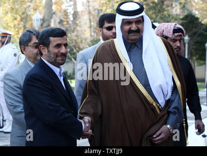 Iranian President Mahmoud Ahmadinejad (L) shakes hands with Qatari Emir Sheik Hamad Bin Khalifa Al Thani during an official welcoming ceremony in Tehran, Iran on December 20, 2010.     UPI/Maryam Rahmanian Stock Photo