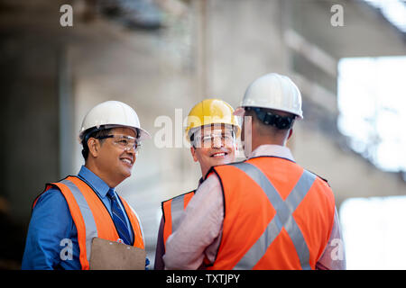Workers at construction site discuss progress. Stock Photo