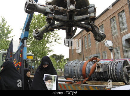 Members of the Basij organization gather around the wreckage of a captured US air force helicopter during ceremony marking the 31st anniversary of a failed US ''rescue'' operation in 1980, inside of the former US embassy in Tehran, Iran on April 25, 2011.       UPI/Maryam Rahmanian Stock Photo