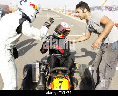 Iranian kart racer Solmaz Hamzadeh (C) speaks with his competitors before his match at Parand International Karting complex on July 22, 2011,in Parand, Iran. In this game Hamzadeh is the only female racer that competes against male competitors.     UPI/Maryam Rahmanian Stock Photo