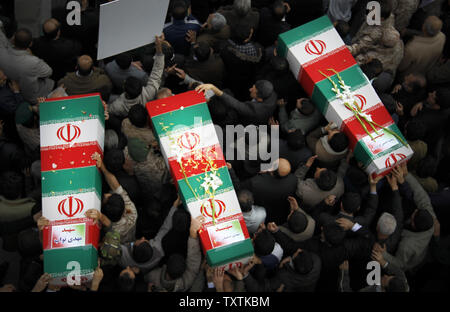 Iranians carry the flag draped coffins containing the remains of a  Revolutionary Guard soldiers  who were killed in explosion in Bidegeneh village, about 35 Kilometers (21 miles) west of Tehran. The explosion happened on Saturday when  a munitions depot caught fire at the IRGC base in Bidgeneh village. The Total of 17 IRGC forces, including Maj. Gen. Hassan Tehrani Moqaddam, director of the Guard's Jihad Self-Sufficiency Organization were killed and 16 others were seriously injured. Tehran, Iran , November 14, 2011.     UPI/Maryam Rahmanian. Stock Photo