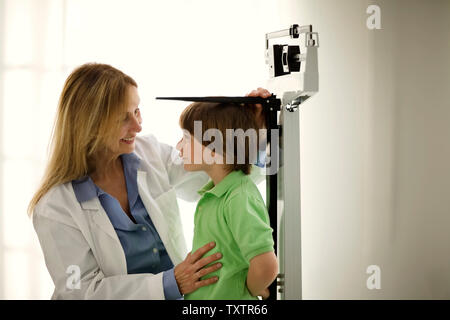 Doctor measuring a young boy's height. Stock Photo