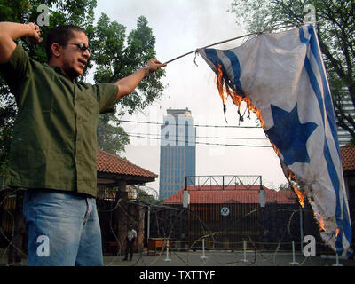 Muslim protesters burn an Israeli flag during demonstration outside the United States embassy in Jakarta, Indonesia on November 8, 2004.  The protest was against Israel and United States policies in the Middle East. (UPI Photo/Saprizal) Stock Photo