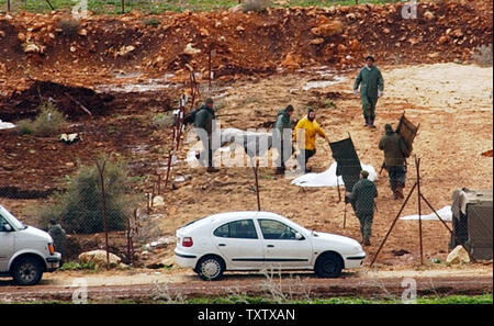 The Israeli army exhumes the bodies of Hizbollah militants in a graveyard in Amiad, in northern Israel, January 27, 2004, in preparation for the completion of a controversial prisoner exchange. In a prisoner swap brokered by Germany, Israel will receive the bodies of three slain Israeli soldiers and an Israeli businessman in exchange for releasing 59 bodies of Hizbollah fighters and more than 400 Arab prisoners. (UPI Photo/Debbie Hill) Stock Photo