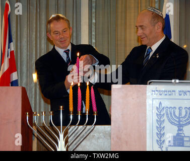 Israeli Prime Minister Ehud Olmert (R) helps British Prime Minister Tony Blair light a Hanukkah candle before a joint press conference at his residence in Jerusalem on December 18, 2006. (UPI Photo/Debbie Hill) Stock Photo