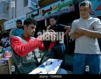 A Palestinian vendor assembles a toy gun in a Ramadan market in central Ramallah, West Bank, October 10, 2007. Palestinians buy toy guns as gifts for children to mark the end of the holy month of Ramadan and to celebrate the three day holiday of Eid al-Fitr. (UPI Photo/Debbie Hill) Stock Photo