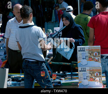 A Palestinian vendor sells toy guns in a Ramadan market in central Ramallah, West Bank, October 10, 2007. Palestinians buy toy guns as gifts for children to mark the end of the holy month of Ramadan and to celebrate the three day holiday of Eid al-Fitr. (UPI Photo/Debbie Hill) Stock Photo