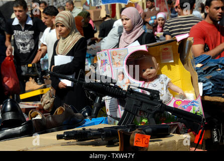 A Palestinian vendor sells toy guns and dolls at a special Ramadan market in central Ramallah, West Bank, October 10, 2007. Palestinians buy toy guns as gifts for children to mark the end of the holy month of Ramadan and to celebrate the three day holiday of Eid al-Fitr. (UPI Photo/Debbie Hill) Stock Photo