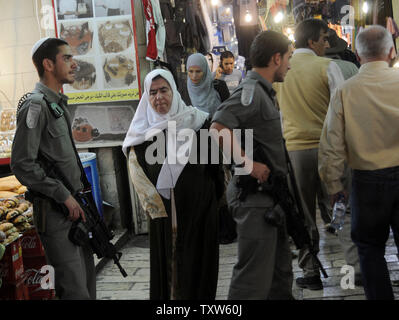 Arab women walk past Israeli border police in the Old City of Jerusalem, November 10, 2008. Jerusalem residents will elect a new mayor tomorrow to head Jerusalem, the Holy City for three major religions.  The mayoral candidates include  Nir Barkat, a secular high tech investor, Arkadi Gaydamak, a Russian billionaire and an Ultra-Orthodox Rabbi Meir Porush. (UPI Photo/Debbie Hill) Stock Photo