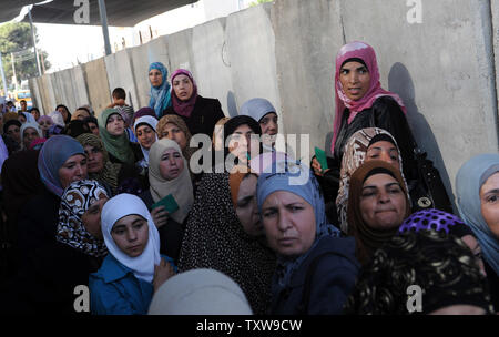 Palestinians women look at Israeli border police, not seen, while they wait for permission to cross the Israeli controlled Bethlehem checkpoint on their way to Jerusalem to pray at the Al-Aqsa Mosque on the second Friday of the Muslim holy month of Ramadan, August 20, 2010.  UPI/Debbie Hill Stock Photo