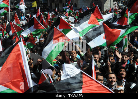 Palestinians wave flags and chant slogans during a rally calling for reconciliation between rival Palestinians factions Hamas in Gaza and Fatah in the West Bank, in Al Manara Square in Ramallah, West Bank, March 15, 2011.  Thousands of Palestinians called on leaders to end the feud that has divided the Palestinian people in Gaza and the West Bank.   UPI/Debbie Hill