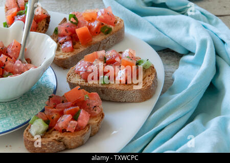 Close up view of tasty tomato Italian appetizers -  bruschetta, on slices of toasted baguette Stock Photo