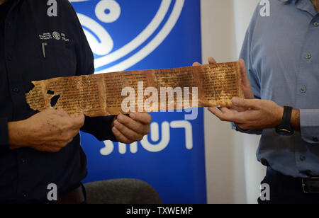 Left, Director General of the Israel Antiquities Authority Shuka Dorfman and, right, Professor Yossi Matias, Managing Director of Google Israel, hold a replica of a segment from the Dead Sea Scrolls, of the 2,000 year old manuscript of the Ten Commandments from the book of Deuteronomy during a press conference at the Rockfeller Museum in Jerusalem, Israel, December 18, 2012.The Israel Antiquities Authority and Google Israel announced the publishing of the Dead Sea Scrolls Digital Library online at a press conference today. The digital library will eventually hold tens of thousands of fragments Stock Photo