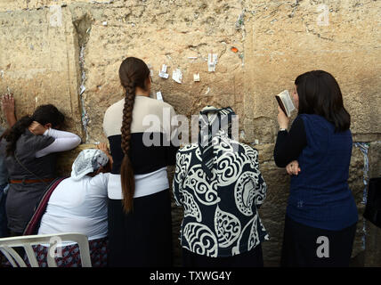 Jewish women pray in front of prayer notes taped to the Western Wall, Judaism's holiest site, in Jerusalem, Israel, June 9, 2013.  More than 300 women from Women of the Wall prayed behind a barrier at the Western Wall as border police prevented Ultra-Orthodox men from reaching them while they wore tefillin and prayer shawls to celebrate the first day of the Jewish month Tamuz. Women of the Wall have fought for religious freedom and women's rights at the Western Wall for more than twenty-five years. UPI/Debbie Hill Stock Photo