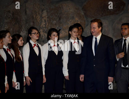 British Prime Minister David Cameron greets an Israeli choir at the end of a memorial ceremony in the 'Hall of Remembrance' at the Yad Vashem Holocaust Museum in Jerusalem, Israel, March 12, 2014. The memorial ceremony honored  the six-million Jews who perished under the Nazi's during World War II.  It is Cameron's first state visit to Israel and the Palestinian territories..UPI/Debbie Hill.
