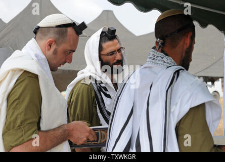 Israeli soldiers wear the traditional Jewish prayer shawl during morning prayers at an army staging area at an unspecified  location near the Israeli border with the Gaza Strip in southern Israel,  July 28, 2014.  Fighting between Israel and Hamas was quieter on the first day of the Muslim holiday of Eid Al Fitr, after pressure from the UN Security Council and US President Barak Obama for an immediate ceasefire.  UPI/Debbie Hill Stock Photo