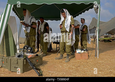 Israeli soldiers wear the traditional Jewish prayer shawl during morning prays at an army staging area at an unspecified  location near the Israeli border with the Gaza Strip in southern Israel,  July 28, 2014.  Fighting between Israel and Hamas was quieter on the first day of the Muslim holiday of Eid Al Fitr, after pressure from the UN Security Council and US President Barak Obama for an immediate ceasefire.  UPI/Debbie Hill Stock Photo